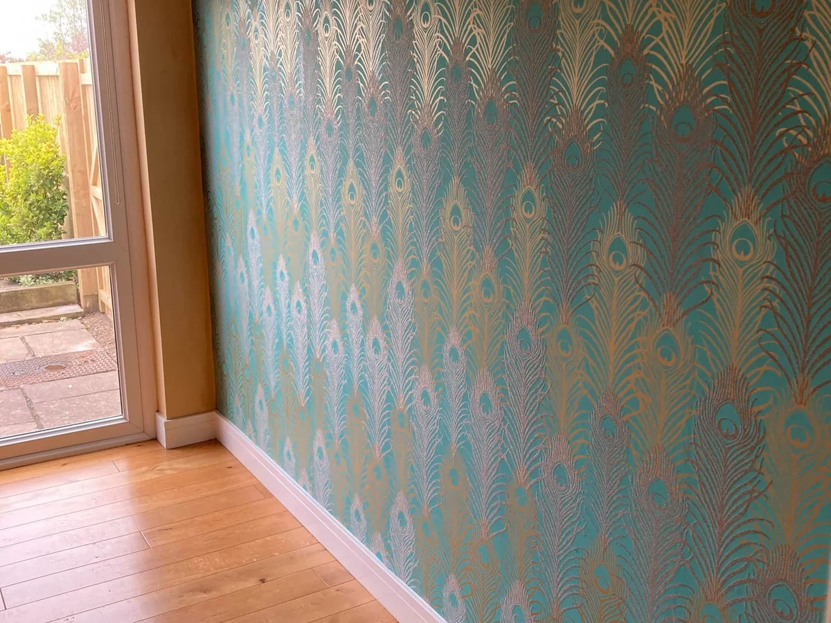 Peacock-pattern feature wall in teal and copper after decoration in a Swansea home