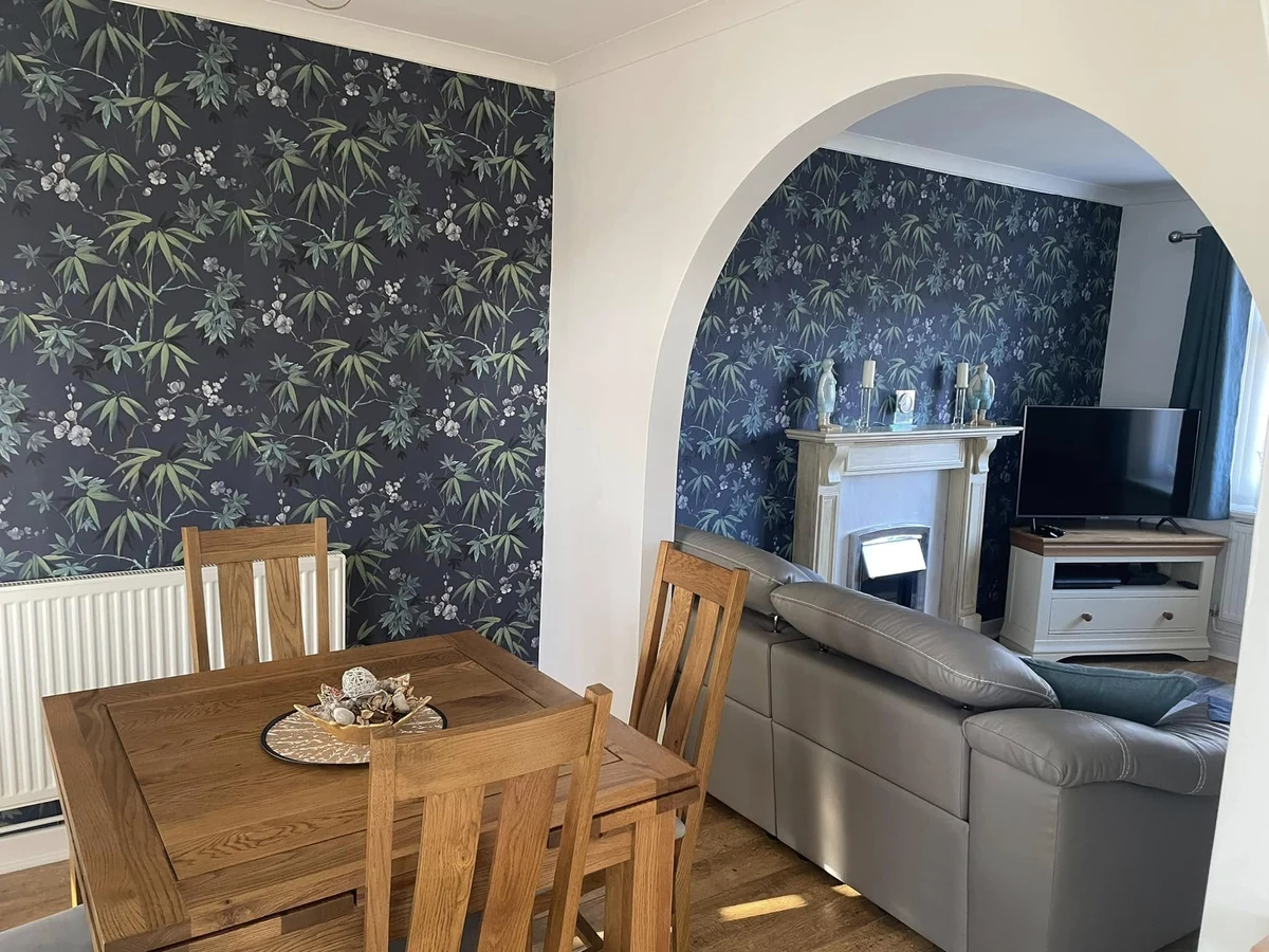 Finished dining and living rooms connected by an open archway in a Swansea home