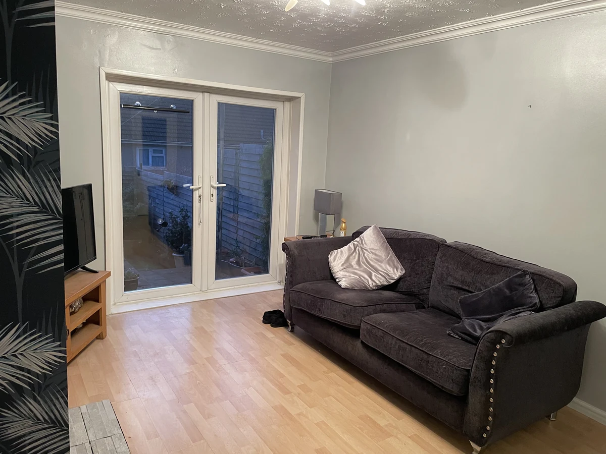 Finished Swansea living room with a blue feature wall, new flooring and seating