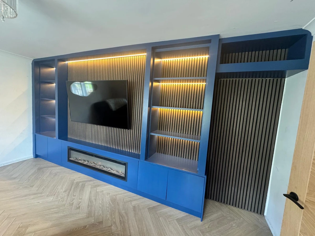 Finished blue media wall with fitted shelving and herringbone floor in Swansea