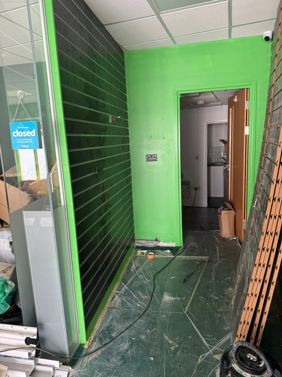 Bright green feature wall and rear doorway inside the Wimozee Technology shop fit-out, Morriston